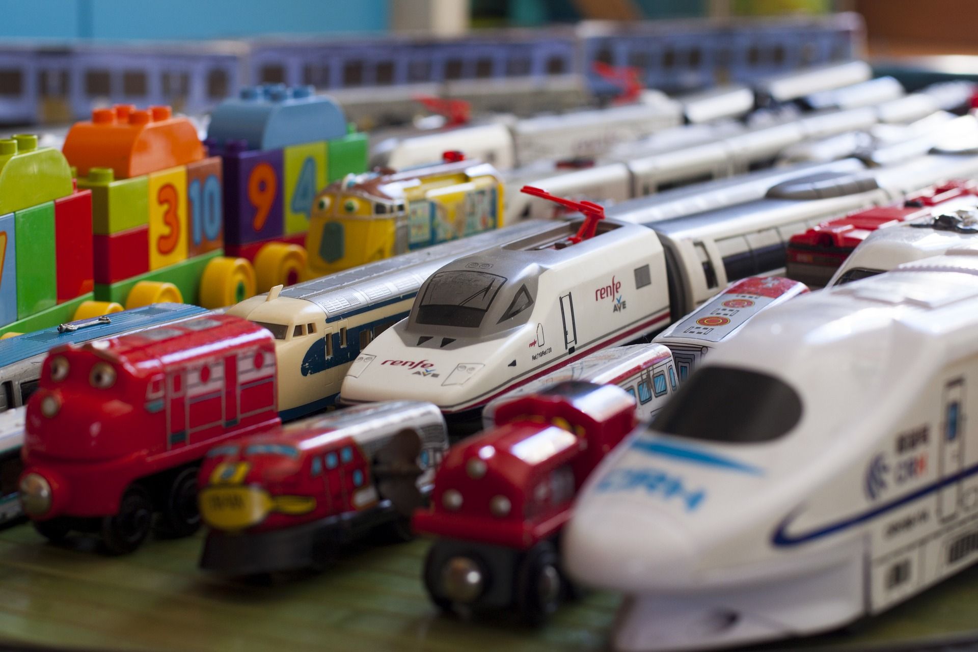 Toy trains lined up on a wooden floor