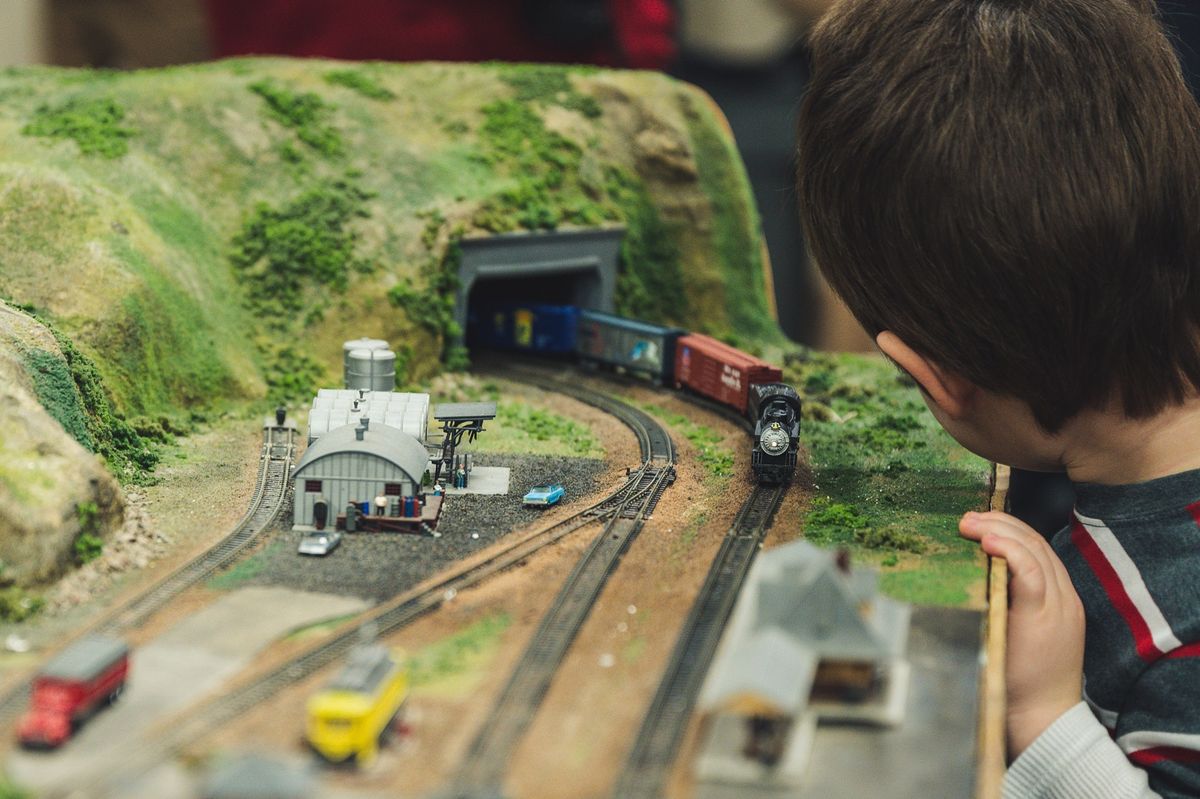 A child browsing train sets in a model rail store